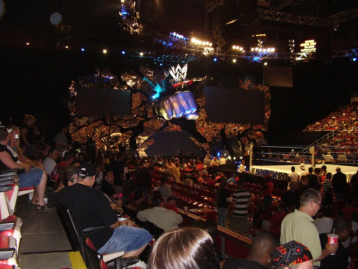 Wide view of a WWE Raw arena with the ring, entrance stage and crowd visible