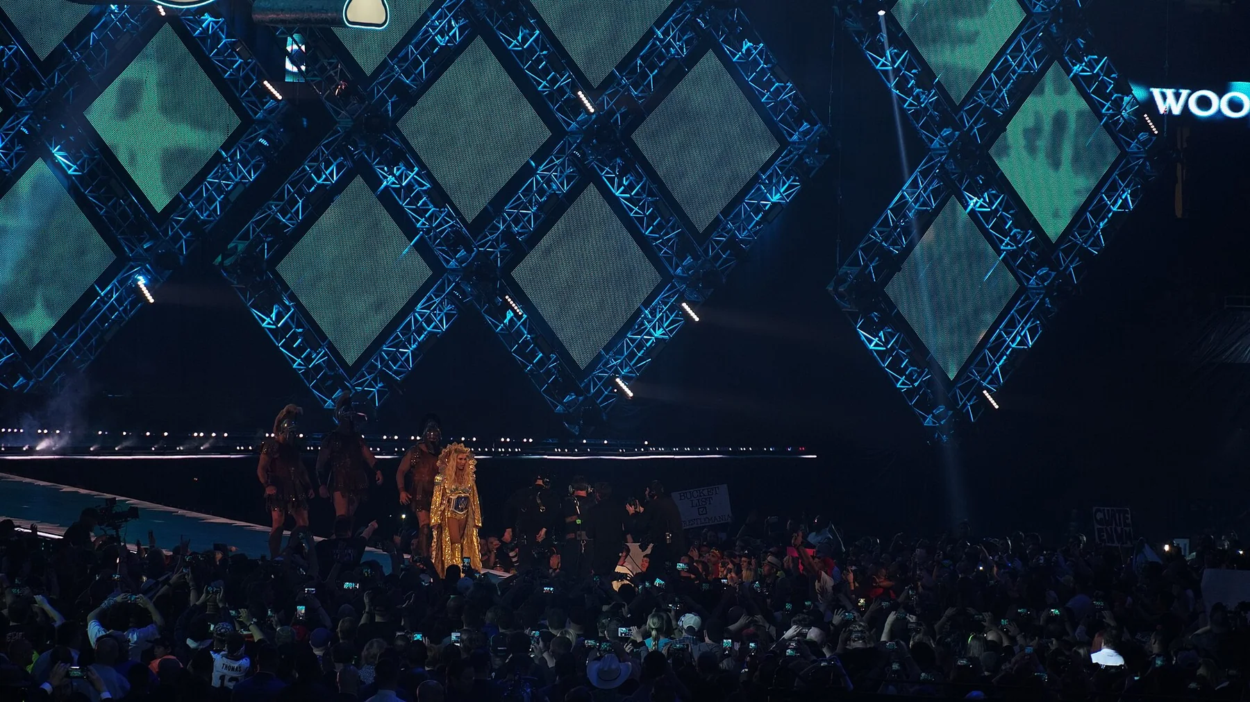 Charlotte Flair standing inside a WWE ring at a live event